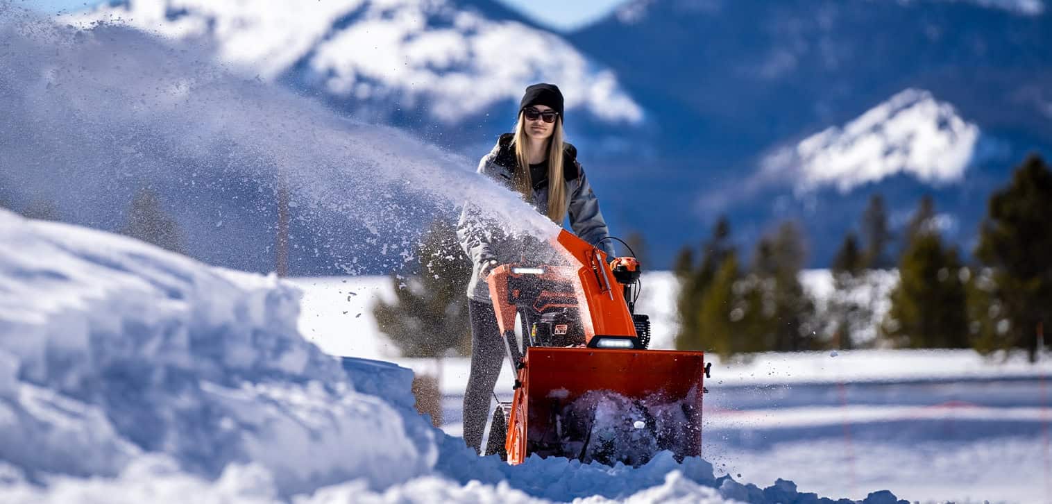 Woman having fun while using a Ariens Snow Blower in heavy snow